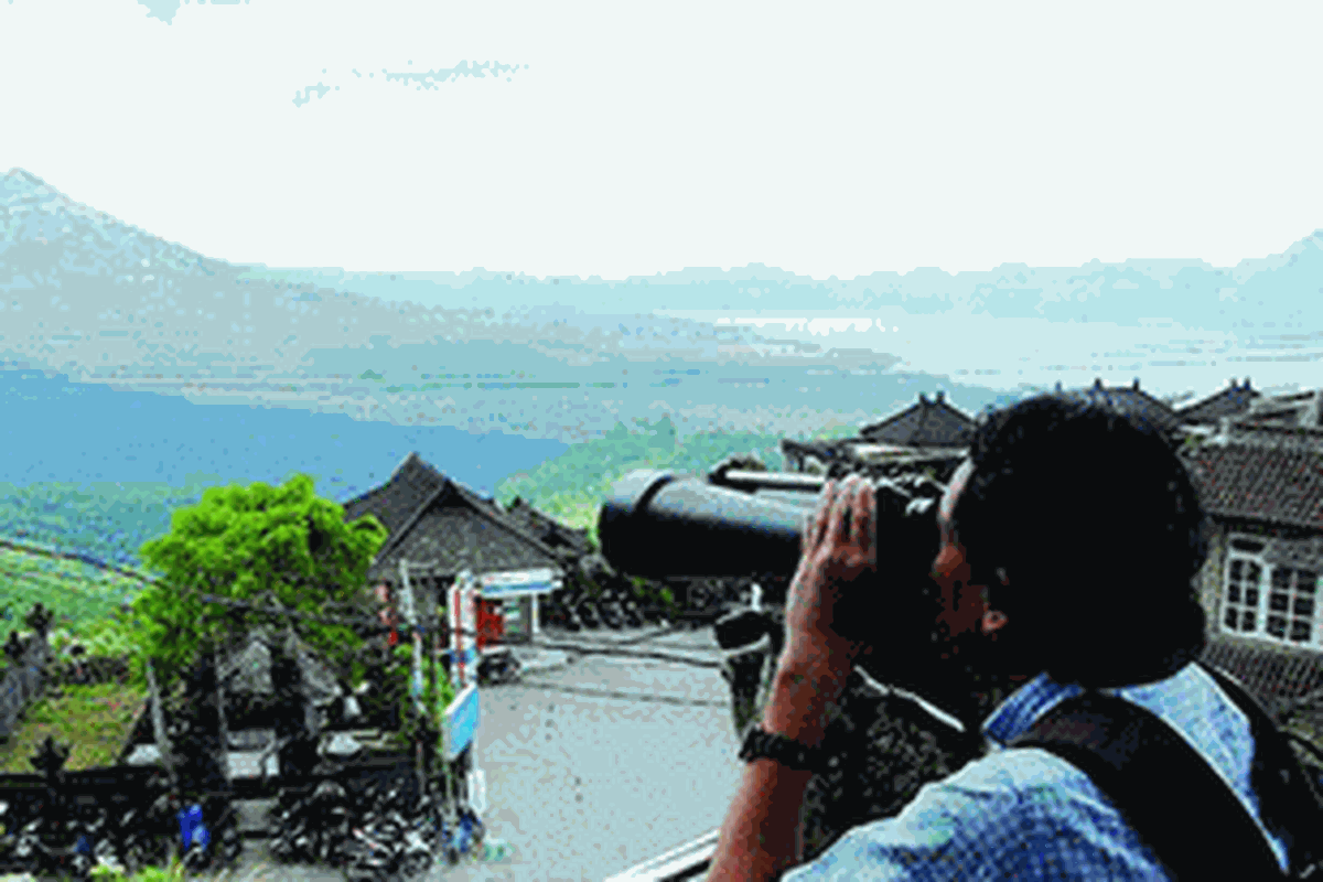 Pengunjung mengamati Gunung Batur dengan teropong di Museum Gunung Api Batur di Kintamani, Kabupaten Bangli, Provinsi Bali, Minggu (3/6/2012). Kawasan Batur kini telah diusulkan menjadi taman bumi (geopark) ke UNESCO. Kekayaan jejak geologi, arkeologi, keragaman hayati, serta kekhasan budaya masyarakatnya menjadi aspek yang menonjol dari kawasan tersebut.