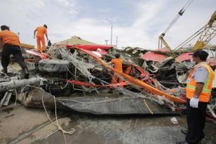 Anggota Basarnas kembali mencari bagian jenazah yang mungkin masih ada di dalam bangkai pesawat yang telah dibawa ke Pelabuhan Tanjung Priok, Jakarta, Senin (2/3/2015).