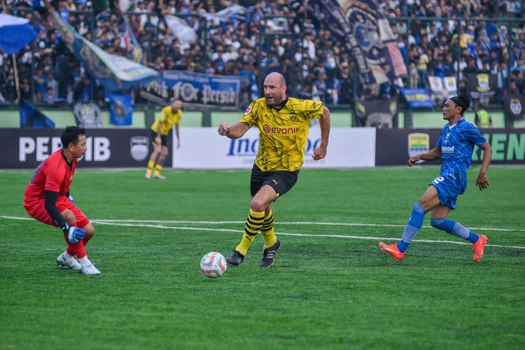 Jan Koller Legenda tim asal Jerman Borussia Dortmund berusaha melewati adangan penjaga gawang I Made Wirawan dalam laga persahaabtan Persib All Stars vs Borussia Dortmund Legend, Minggu (10/9/2024) di Stadion Siliwangi Bandung. 