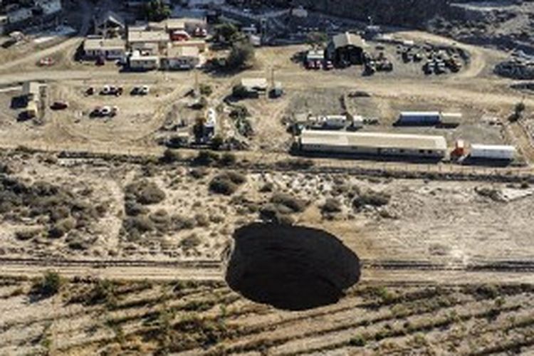 Pemandangan udara diambil pada 1 Agustus 2022, menunjukkan lubang pembuangan besar yang muncul selama akhir pekan di dekat kota pertambangan Tierra Amarilla, Provinsi Copiapo, di Gurun Atacama di Chile. 