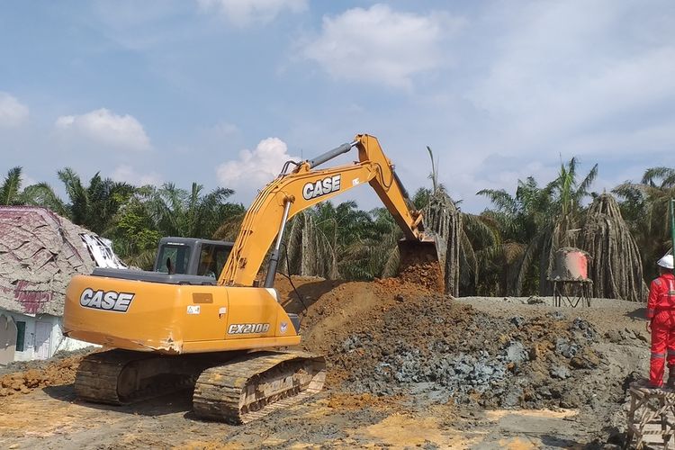 Eskavator dari Dinas PUPR-PKP Provinsi Riau membuat sekatan untuk mengantisipasi semburan lumpur mengalir ke pekarangan Ponpes IBS Riau Kampus 2 di Kelurahan Tuah Negeri, Kecamatan Tenayan Raya, Kota Pekanbaru, Riau, Rabu (10/2/2021).