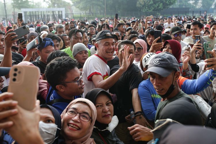 Gubernur Jawa Tengah sekaligus bakal calon presiden yang diusung Partai Demokrasi Indonesia Perjuangan, Ganjar Pranowo menyapa simpatisan saat lari pagi di kawasan Stadion Gelora Bung Karno, Jakarta, Minggu (30/4/2023).