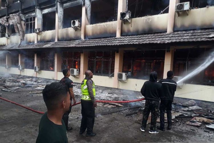 Petugas Damkar dan dibantu personel TNI-Polri sedang berusaha memadamkan api yang menghanguskan enam OPD di Pemkab Jayapura, Minggu (29/10) 2023.