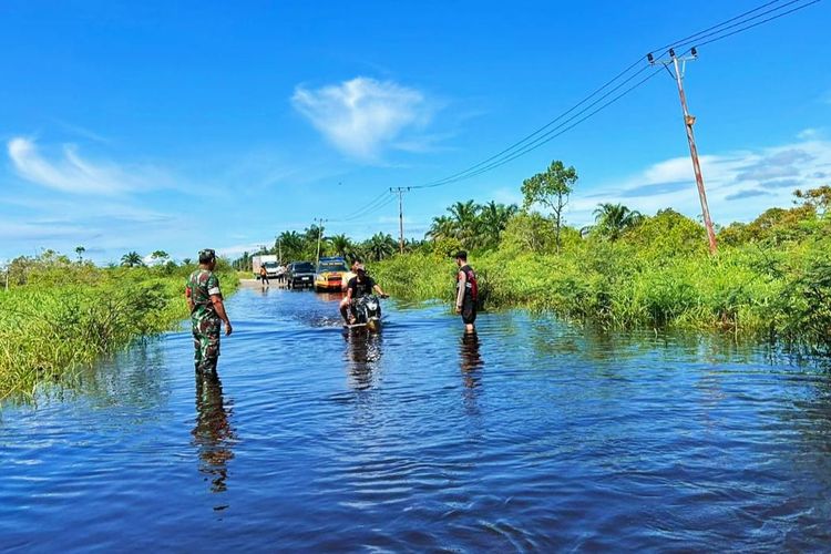 Petugas TNI dan Polri memantau kondisi banjir yang merendam jalan lintas Rohul-Bengkalis, di Desa Sontang, Kecamatan Bonai Darussalam, Kabupaten Rokan Hulu, Riau, Rabu (25/10/2023).