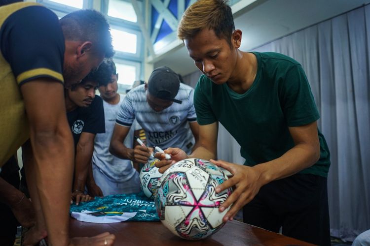 Pemain Nusantara United FC menandatangani bola dan jersey saat pembubaran tim