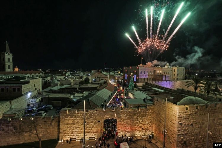 Kembang api menerangi langit saat warga menghadiri penyalaan pohon Natal di Gerbang Jaffa, kota tua Yerusalem, 11 Desember 2022.