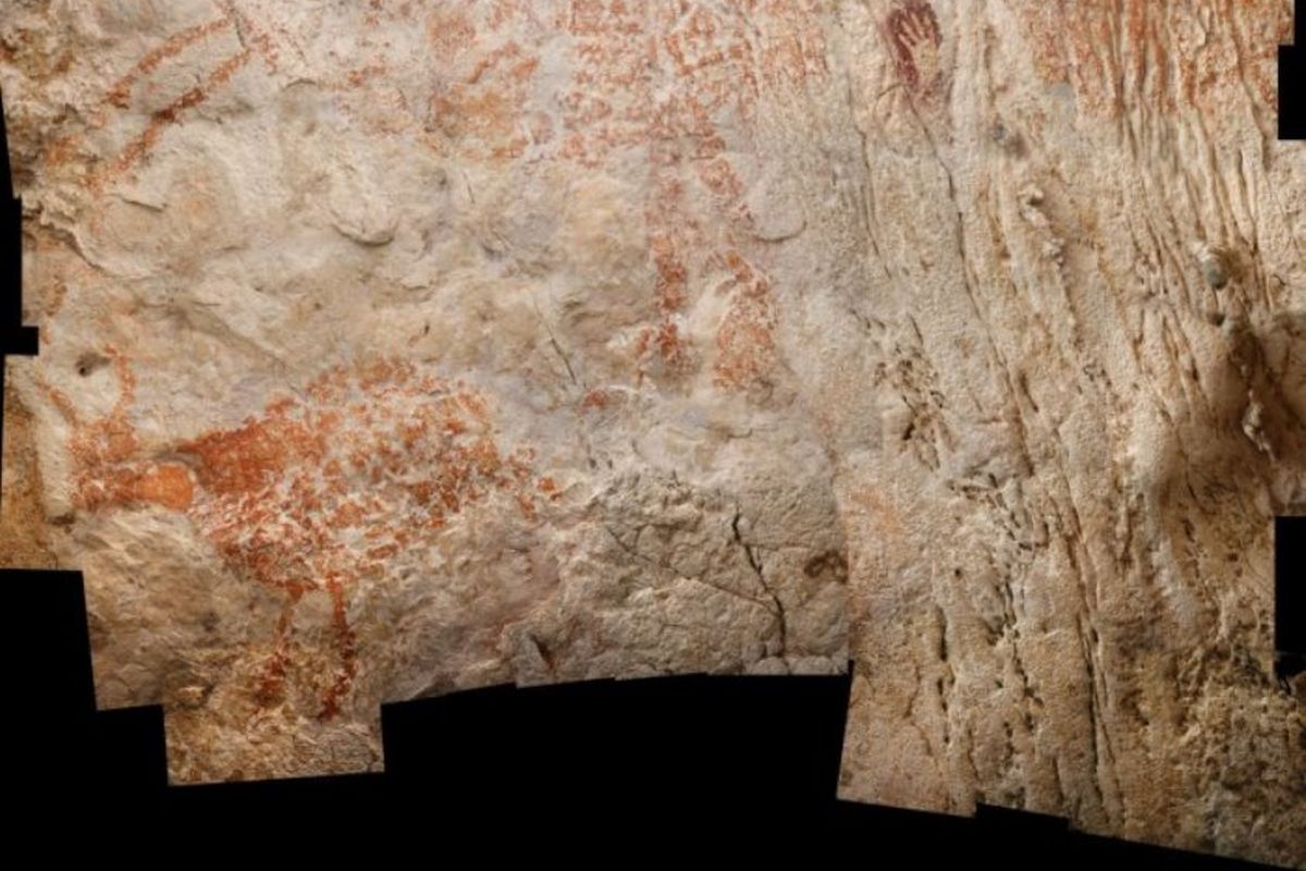 siluet cap tangan manusia purba yang letaknya masih satu bidang dengan lukisan gua tertua di dunia.