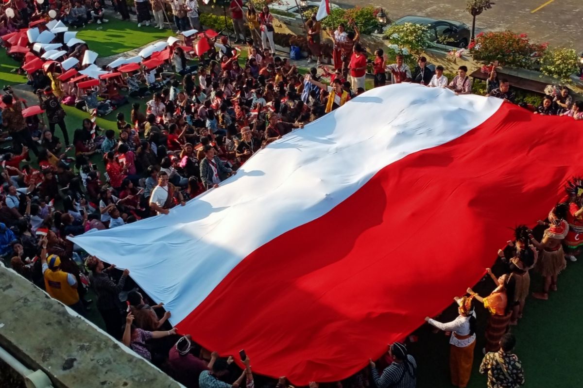 Para pelajar beragama Kristen bentangkan bendera merah putih raksasa. 