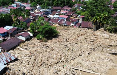 KAYU GELONDONGAN: Foto udara tumpukan gelondongan kayu di permukiman di Tabiang Bandang Gadang, Nanggalo, Padang, Sumatera Barat, Selasa (9/12/2025). Gelondongan kayu yang terbawa banjir bandang sejak dua pekan lalu masih tersangkut di wilayah itu.