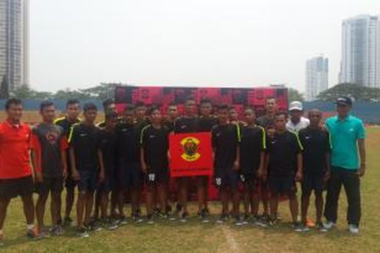 Meydi Rifki Aji Saputra (tengah memegang papan merah), pemenang Nike Most Wanted Indonesia 2014 saat berpose bersama rekan-rekannya dan staf pelatih seusai pertandingan uji coba melawan tim nasional U-17 di Stadion Soemantri Brodjonegoro, Jakarta, Minggu (26/10/20140). 