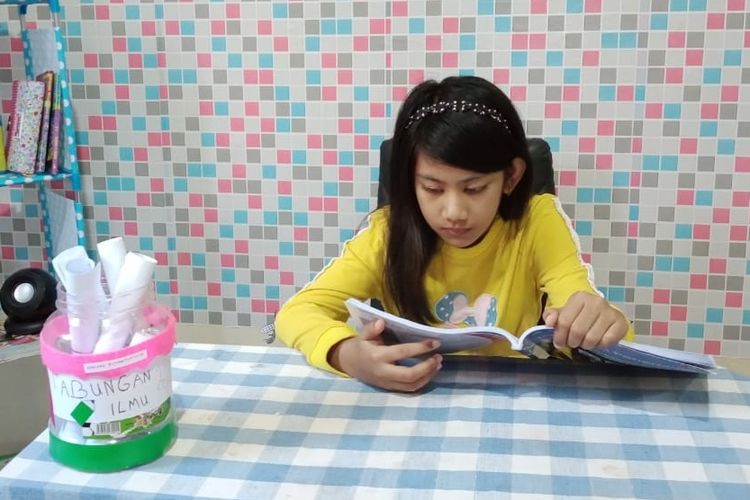 Faizah, siswi  SDN 005 Kuala Tungkal, Tanjung Jabung Barat, Jambi, membaca buku dari pojok baca yang dibuatnya, setelah membaca ia menulis resume bacaannya dan ditaruh tabungan ilmu yang terbuat dari kotak plastik.