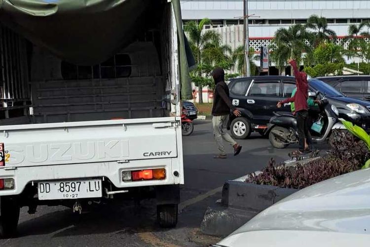 Beberapa 'Pak Ogah' yang sedang mengatur kendaraan roda empat untuk berbelok arah di U-turn ruas Jalan A P Pettarani, Kota Makassar, Sulawesi Selatan (Sulsel). Selasa (9/5/2023)