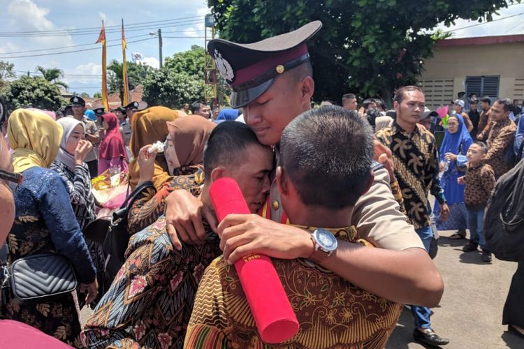 Rahmad memeluk kedua orang tuanya seusai acara pelantikan bintara muda Polri di SPN Polda Metro Jaya, Cigombong, Bogor, Jawa Barat