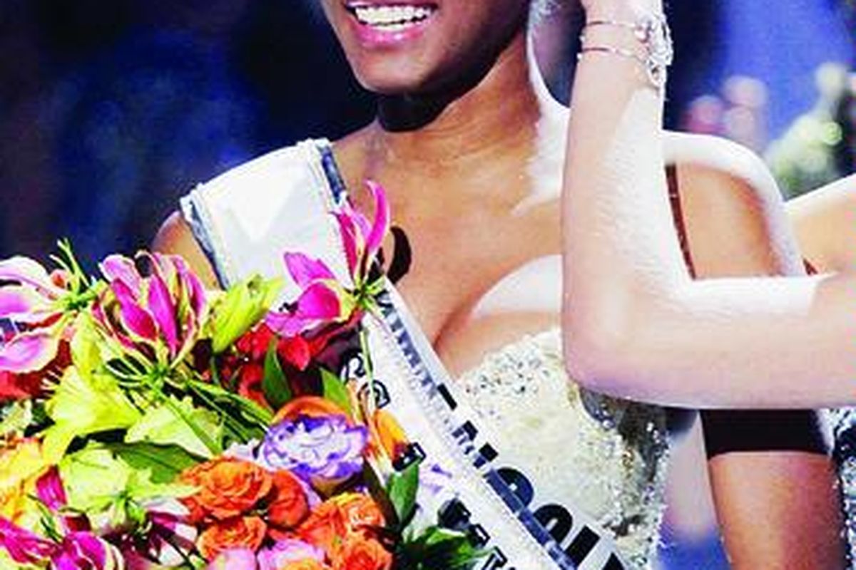 Miss Angola Leila Lopes yang terpilih sebagai Miss Universe 2011 tersenyum saat Miss Universe 2010 Ximena Navarrete dari Meksiko memasangkan mahkota di Sao Paulo, Brasil, Senin (12/9).