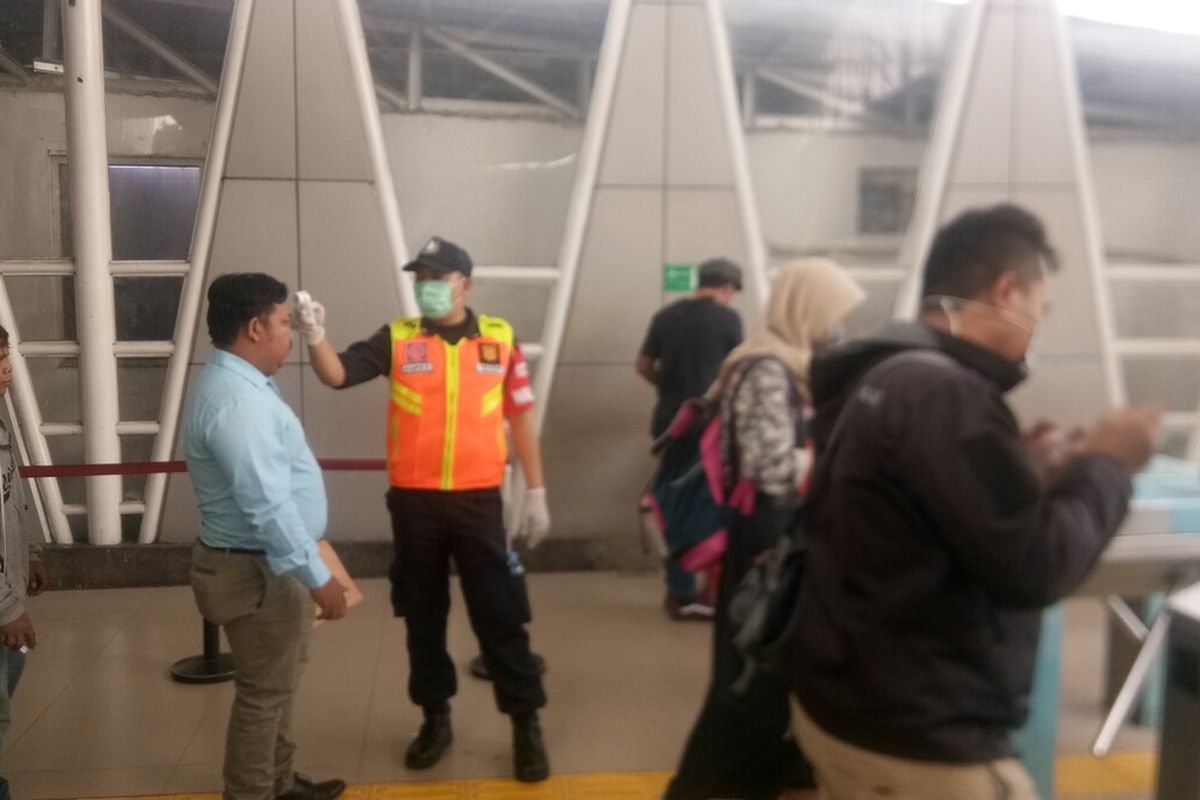 Petugas sedang melakukan pengecekan suhu tubuh terhadap para calon penumpang KRL di Stasiun Bogor, Senin (16/3/2020).