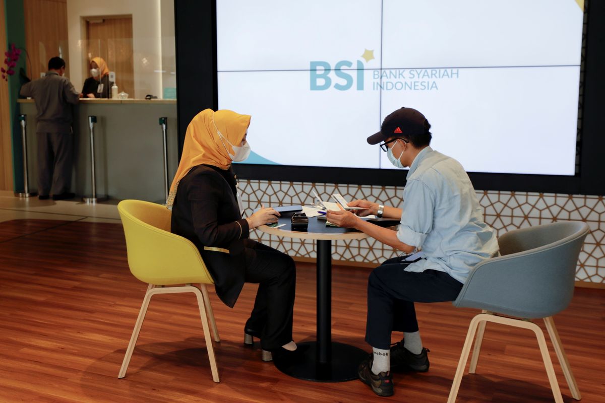Bank workers serve customers in a Bank Syariah Indonesia branch in Jakarta (8/6/2021)