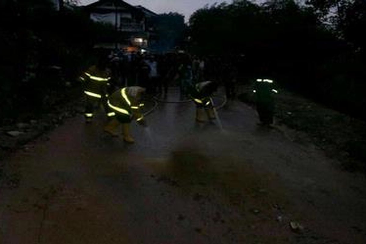 Penyemprotan badan jalan yang tertutup lumpur oleh Dinas Pemadam Kebakaran Kabupaten Bandung Barat