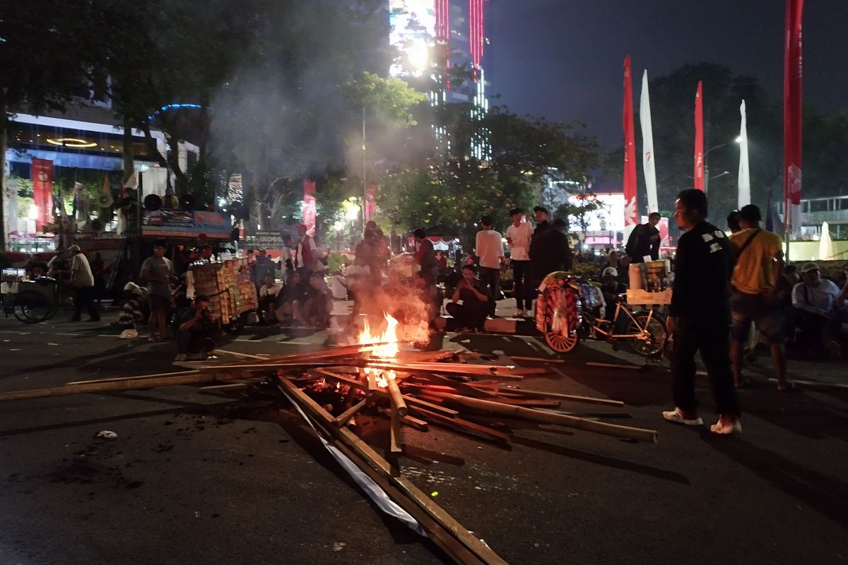 Massa buruh membakar sejumlah bambu saat demo di depan Patung Kuda Arjuna Wiwaha, Gambir, Jakarta Pusat, Kamis (10/8/2023) malam. (KOMPAS.com/XENA OLIVIA)