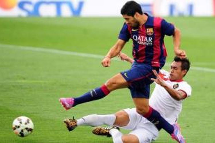 Duel pemain FC Barcelona Luis Suarez (depan) dengan pemain Timnas Indonesia U-19, Hansamu Yama dalam pertandingan persahabatan antara FC Barcelona B vs Timnas Indonesia U-19 di Pusat Olahraga FC Barcelona Joan Gamper di San Joan Despi, Spanyol, 24 September 2014.