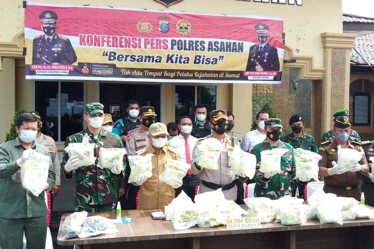 Kapolres Asahan, AKBP Putu Yudha Prawira (tengah) menunjukkan barang bukti sabu-sabu yang diamankan di pinggir sungai di sungai di Dusun II, Desa Sei Apung, Kecamatan Tanjung Balai - Asahan yang ditemukan pada Rabu (8/9/2021) sekitar pukul 10.00 WIB saat konferensi pers di Mapolres Asahan, Senin (20/9/2021). Seorang pelaku tertangkap dan empat lainnya melarikan diri.