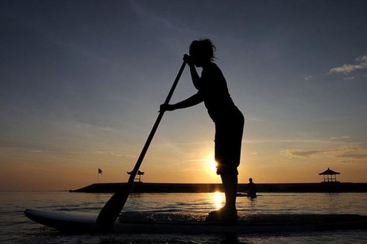 Pelancong menikmati pagi sembari main kano di Pantai Sanur Bali, Minggu (19/2/2017).