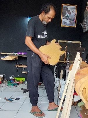 Slamet Joko Santoso mengecek bodi yang akan digunakan membuat gitar pesanan pelanggan