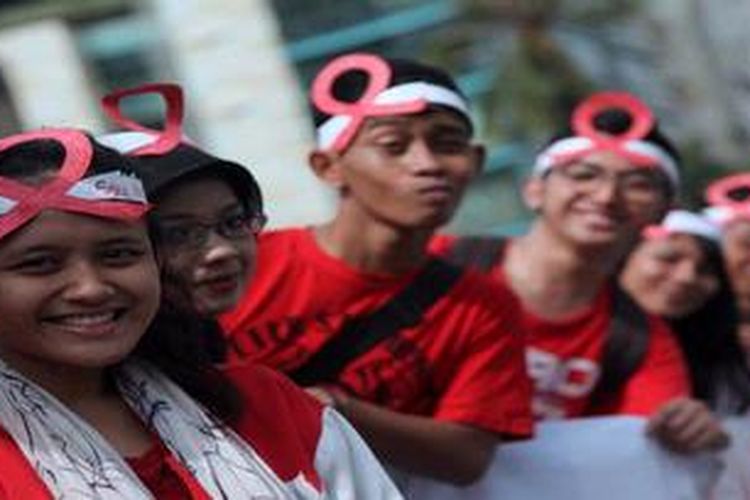 Mahasiswa Uni Sadhu Guna  Business school saat menggelar aksi bagi permen kepada pengguna jalan di Kawasan Bundaran Hotel Indonesia, Jakarta Pusat, Sabtu (1/12/2012). Aksi yang menyerukan untuk mencintai kehidupan itu dilakukan dalam angka memperingati Hari AIDS se dunia.
 
