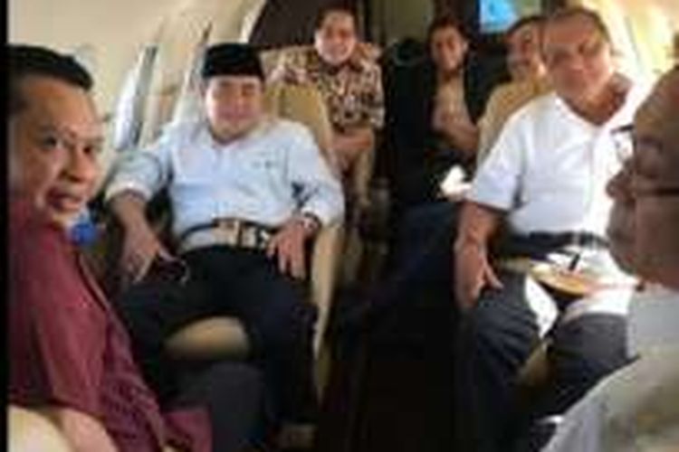 Ketua Dewan Perwakilan Rakyat (DPR) Ade Komarudin (berpeci) bersama dengan politisi Partai Golkar lainnya, Bambang Soesatyo, MS Hidayat, dan Firman Soebagyo dalam sebuah jet pribadi. Foto ini diadukan oleh sebuah LSM yang melaporkan Ade atas dugaan gratifikasi.