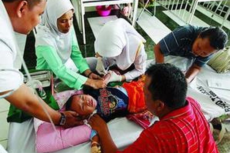 Dengan dibantu orangtua pasien, tiga tenaga medis mengambil contoh darah Adi, pasien demam dengue, yang dirawat di RSUD Tarakan, Jakarta Pusat, Selasa (24/2). Sepanjang tahun 2009, sebanyak 4.290 pasien demam berdarah dirawat di rumah sakit di Jakarta.
