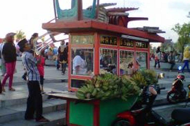 Seorang pedagang pisang epek yang berjualan di anjungan Pantai Losari mengangkat barang-barang dagangnya setelah diusir oleh petugas Satpol PP.