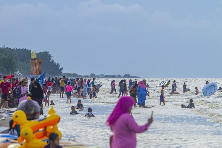 Wisatawan memadati Pantai Tanjung Pakis, Pakisjaya, Karawang, Jawa Barat, Senin (1/6/2020).  Meski penerapan Pembatasan Sosial Berskala Besar (PSBB) Kabupaten Karawang masih diperpanjang hingga 14 Juni 2020, namun masyarakat sudah memadati lokasi wisata yang berada di Pantai Tanjung Pakis Karawang. ANTARA FOTO/M Ibnu Chazar/pras.