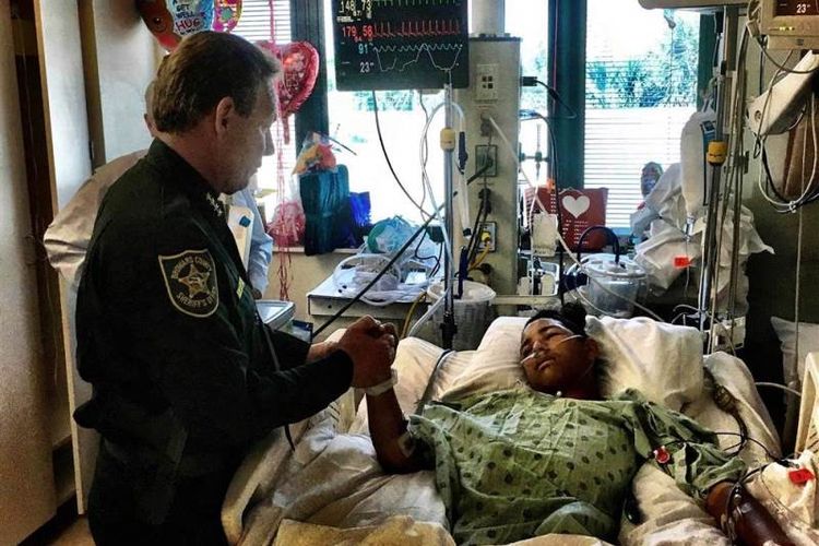 Kepala kepolisian Broward Florida Scott Israel menjenguk korban selamat penembakan sekolah di Florida. Anthony Borges (15), yang kini menjadi pahlawan untuk teman-temannya. (Facebook/Broward Sheriffs Office)
