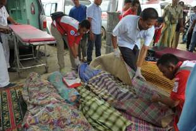 Relawan dari Palang Merah Indonesia mengevakuasi korban tewas akibat tertimpa bangunan yang runtuh akibat gempa bumi berkekuatan 6,4 skala richter, di Pidie, Aceh, Rabu (7/12/2016). Puluhan orang tewas dalam peristiwa yang terjadi pada pukul 05.03 WIB ini.
