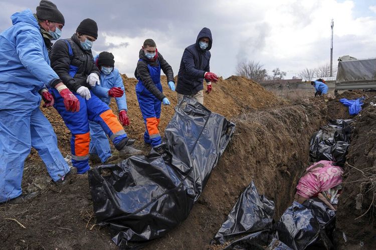Mayat ditempatkan di kuburan massal di pinggiran Mariupol, Ukraina, Rabu, 9 Maret 2022 karena orang tidak dapat menguburkan orang mati mereka karena penembakan berat oleh pasukan Rusia. 