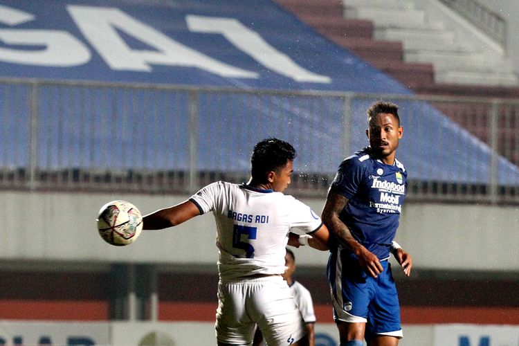 Pemain asing Persib Bandung Wander Luiz duel bola udara dengan pemain Arema FC Bagas Adi pada pertandingan pekan ke-14 Liga 1 2021-2022 yang ber akhir dengan skor 0-1 di Stadion Maguwoharjo Sleman, Minggu (28/11/2021) malam. 