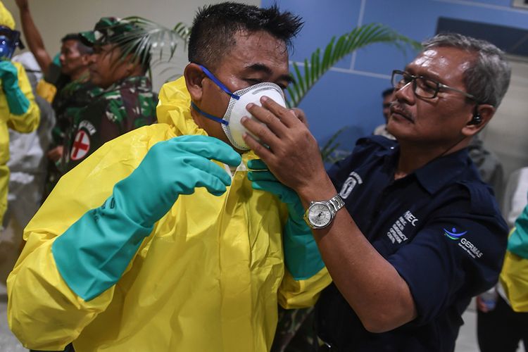 Sejumlah petugas mengenakan pakaian pelindung lengkap saat bersiap menyambut kedatangan kru kapal pesiar Diamond Princess yang dinyatakan negatif virus corona di Bandara Kertajati, Kabupaten Majalengka, Jawa Barat, Minggu (1/3/2020). Pemerintah mengevakuasi 69 kru kapal pesiar Diamond Princess dari Yokohama, Jepang dan selanjutnya akan menjalani proses observasi di Pulau Sebaru Kecil, Kepulauan Seribu, Jakarta.