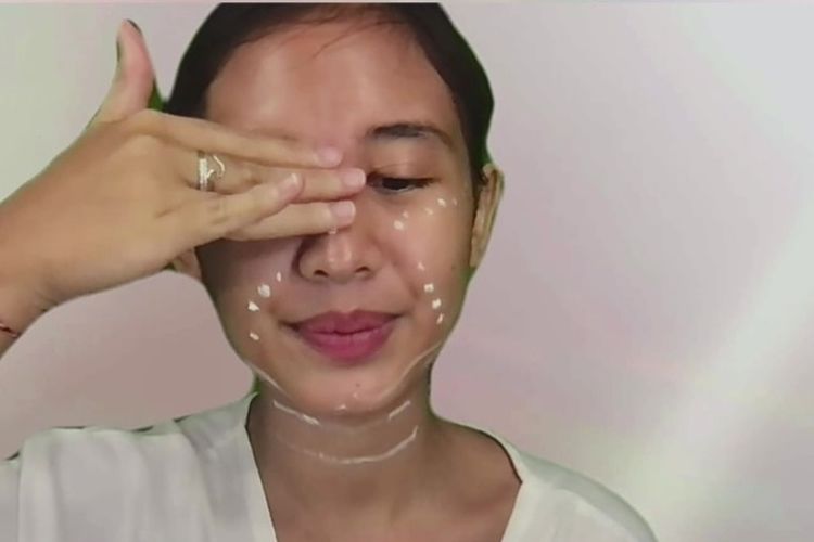 Meratakan produk dari arah dahi ke hidung sambil melakukan pijatan ringan.