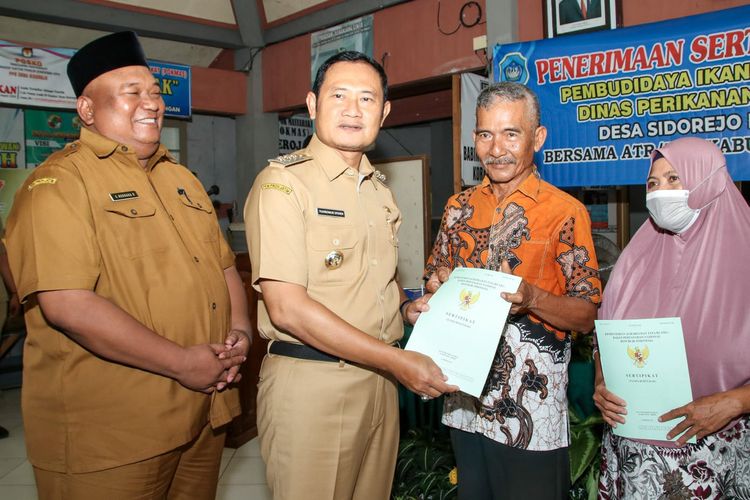 Bupati Lamongan Yuhronur Efendi (dua dari kiri), menyerahkan Sertifikat Hak Atas Tanah Pembudidaya Ikan (Sehatkan) di Desa Sidorejo, Kecamatan Deket, Lamongan, Jawa Timur, Senin (26/12/2022).