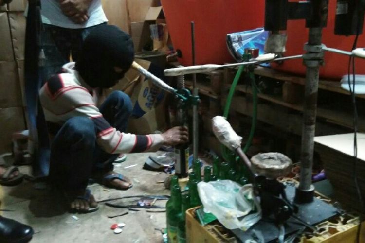 Tersangka pengoplos miras sedang memeragakan cara mengoplos miras di sebuah gudang penyimpanan barang bekas di Kelapa Gading, Jakarta Utara, Jumat (13/10/2017).