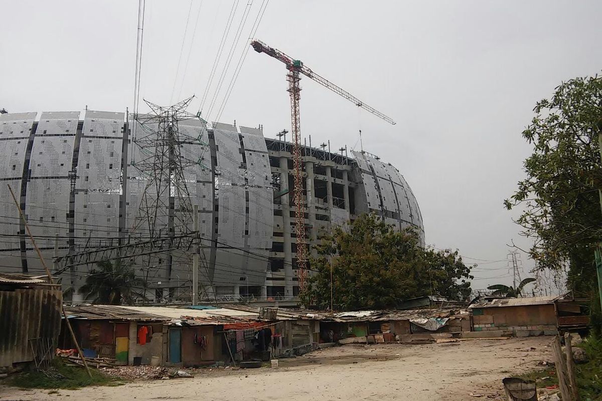 Deretan gubuk yang berada di bantaran rel kereta api, tepat di depan megahnya stadion Jakarta International Stadium (JIS), Tanjung Priok, Jakarta Utara, Rabu (6/1/2022).