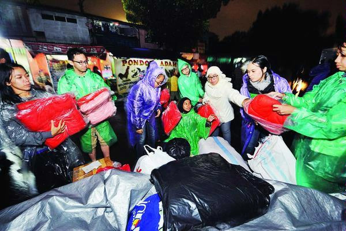 Para sukarelawan dari Sahabat Anak membagikan selimut, terpal, obat, dan bantuan lainnya kepada korban bencana banjir di Kelurahan Manggarai, Tebet, Jakarta Selatan, Kamis (17/1).