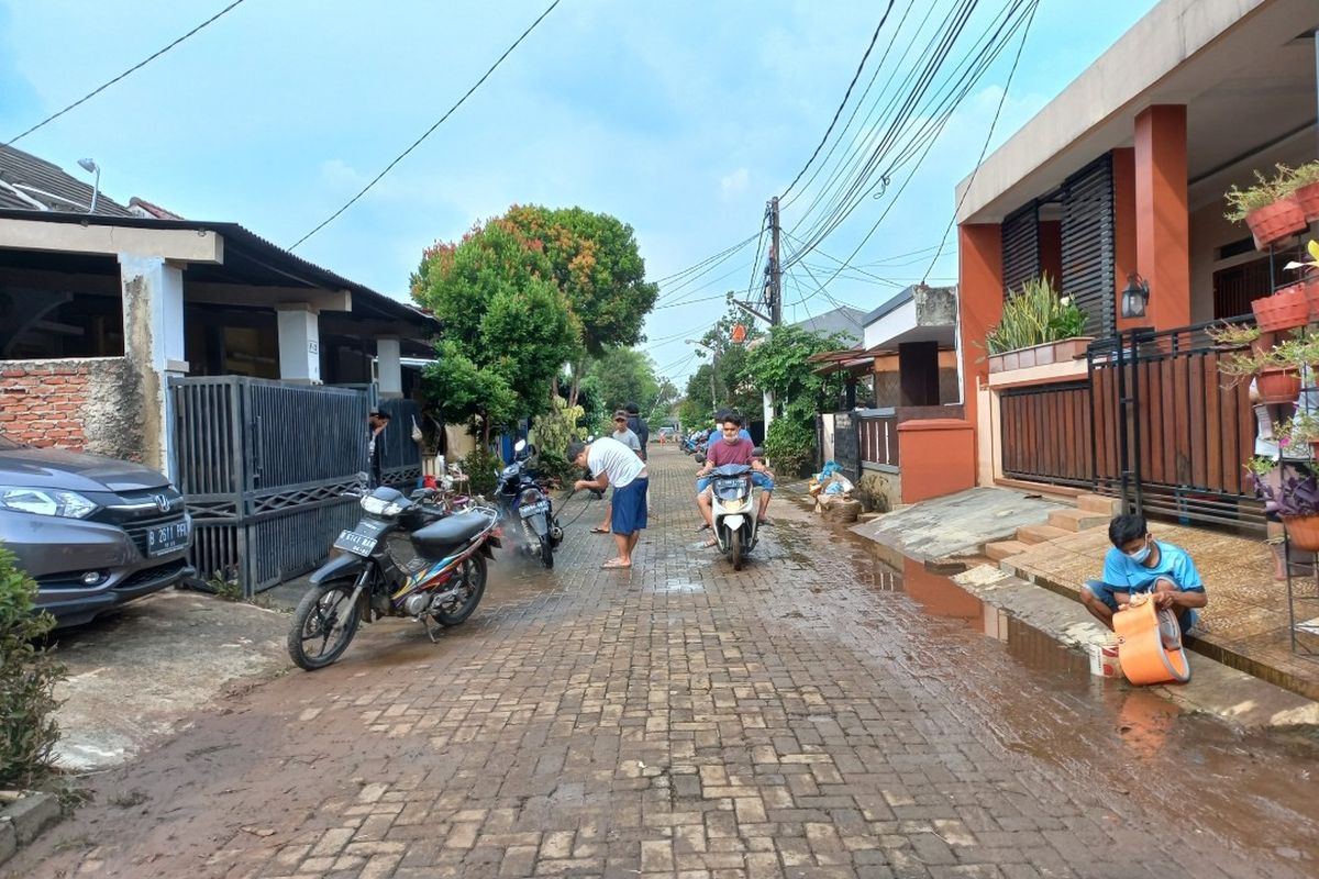 Sejumlah warga membersihkan barang dan kendaraannya usai banjir surut di Perumahan Payung Mas, Ciputat, Tangerang Selatan, Senin (14/6/2021).