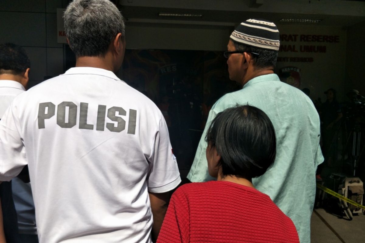 Seorang perempuan (baju merah) dan suaminya (berbaju hijau) menyaksikan putrinya, Suci, memperagakan adegan kasus pengeroyokan anggota TNI di Ciracas yang terjadi Senin pekan lalu. Suci merupakan salah satu tersangka dalam kasus itu. Rekonstruksi kasus itu digelar di Mapolda Metro Jaya, Senin (17/12/2018).