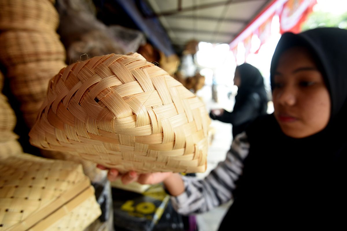 Seorang calon pembeli mencermati besek bambu yang dijual di sebuah kios di Jalan Jatinegara Barat, Jakarta Timur, Sabtu (10/9/2019). Sejumlah pedagang mulai  menjual besek yang terbuat dari bambu untuk membungkus daging kurban saat Idul Adha.