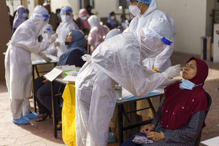 Pekerja medis mengumpulkan sampel usap dari seorang wanita selama pengujian virus corona di pusat pengujian Covid-19 di Kajang, pinggiran Kuala Lumpur, Malaysia Sabtu (8/5/2021) ditengah lonjakan kasus. 