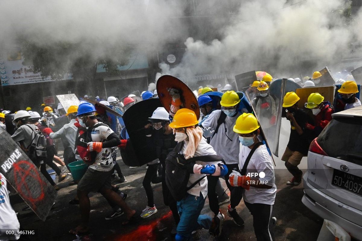 Para pengunjuk rasa memegang perisai buatan sendiri saat mereka berlari selama demonstrasi menentang kudeta militer di Yangon pada Tabu (3/3/2021). 
