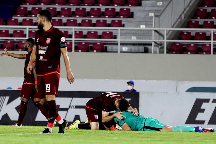 Pemain Borneo FC Nuriddin Davronov memeluk kiper Gianluca Pandenynuwu usai menggagalkan tendangan pemain PSM Makassar pada pertandingan pekan ke-8 Liga 1 2021-2022 yang ber akhir dengan skor 2-1 di Stadion Manahan Solo, Jumat (22/10/2021) malam.