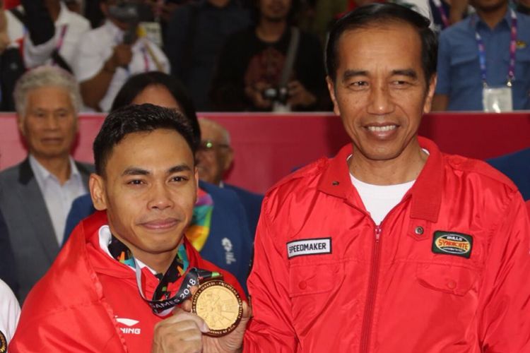 Menko PMK Puan Maharani berfoto bersama lifter Indonesia Eko Yuli Triawan dan Presiden Jokowi (kiri-kanan). Eko berhasil meraih medali emas di cabor angkat besi kelas 62 kilogram di JIExpo Kemayoran, Selasa (21/8/2018).