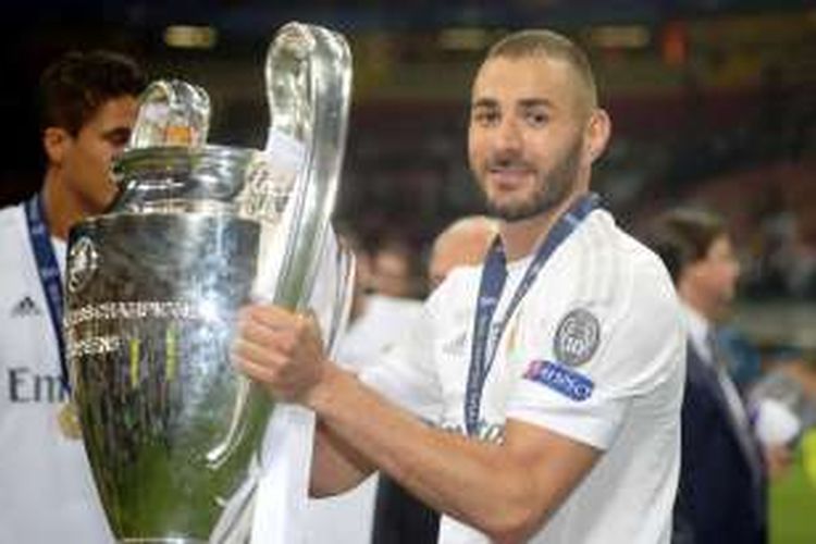 Penyerang Real Madrid, Karim Benzema, berpose dengan trofi seusai El Real menjuarai Liga Champions, Sabtu (28/5/2016). 