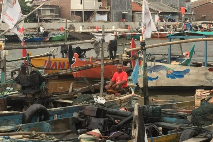 Junedi, seorang nelayan yang kerap beroperasi di wilayah Tambak Lorok, Semarang, sedang memperbaiki mesin kapalnya.